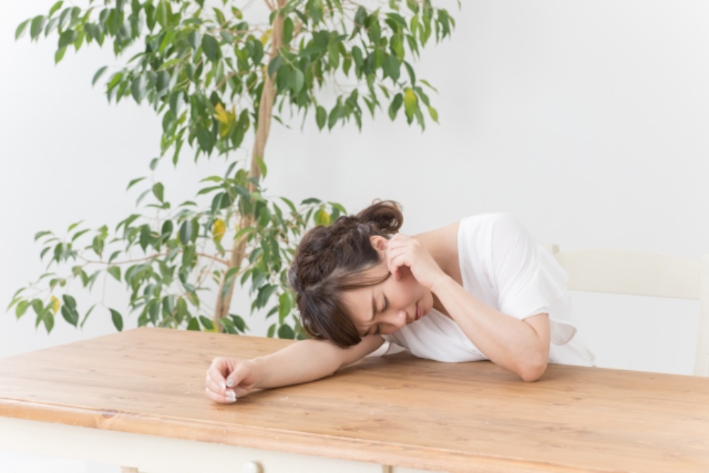 耳を触ってしんどそうにしている女性