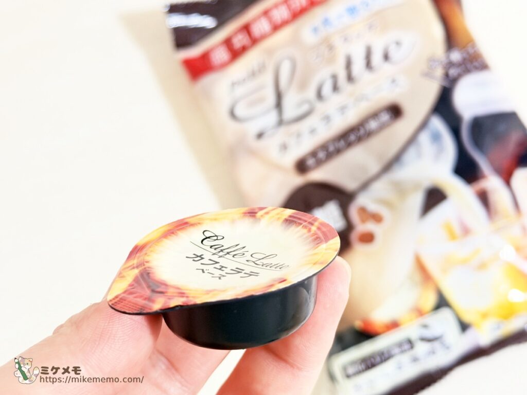 手に持ったカフェラテベースのポーション容器