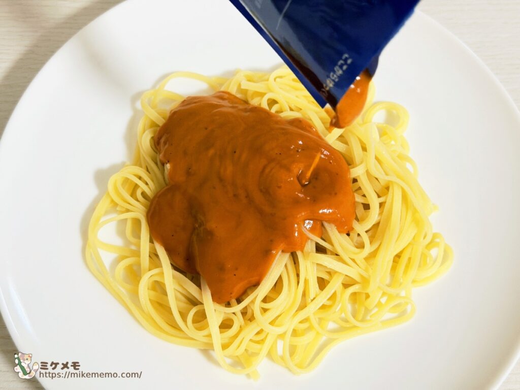 リングイネに海老と帆立のトマトクリームソースをかけているところ