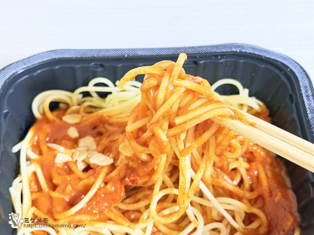 フライドガーリックが見えるカプリチョーザ監修 トマトとニンニクの麺を箸で持ち上げたところ