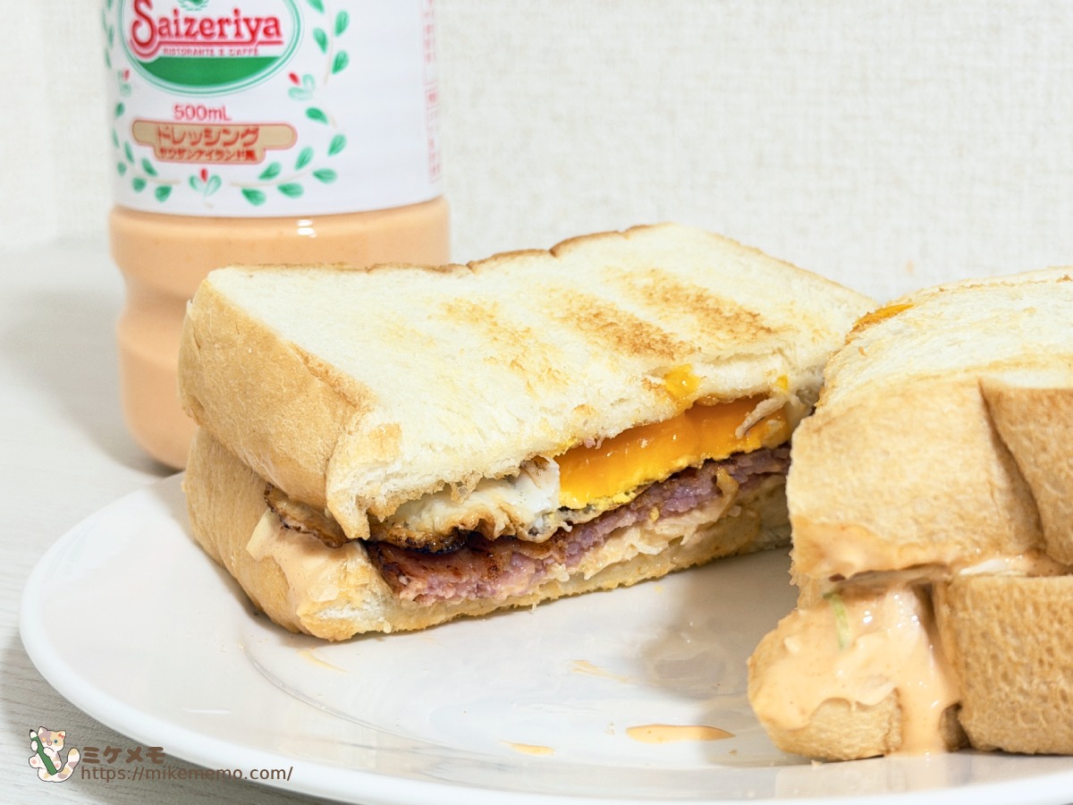 ハムと目玉焼きを挟んだサンドイッチの断面とドレッシングのボトル