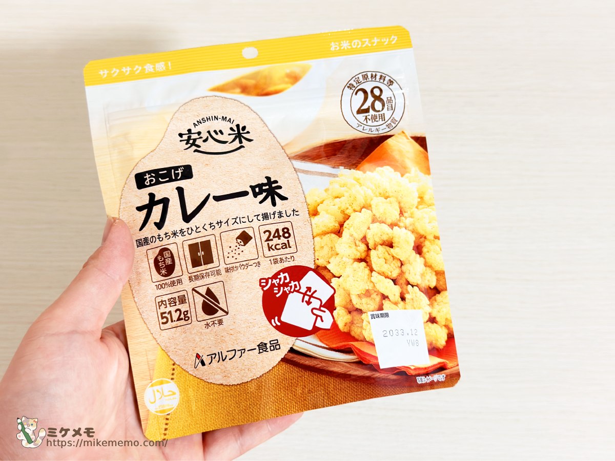 安心米おこげ カレー味のパッケージを手に持ったところ