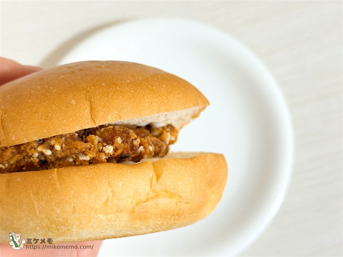 手に持ったファミチキ（ごま山椒味）のバンズサンド