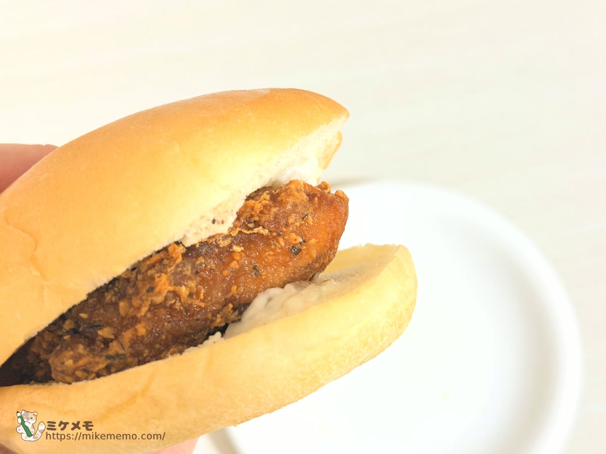 手に持ったファミチキ(ピッツァ味)のバンズサンド